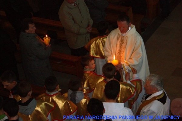 Ministranci i wierni zapalaja swoje świece